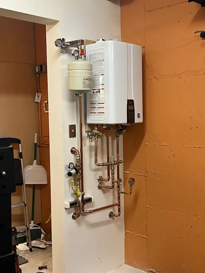 Plumbing technician inspecting water heater connections in Nockamixon